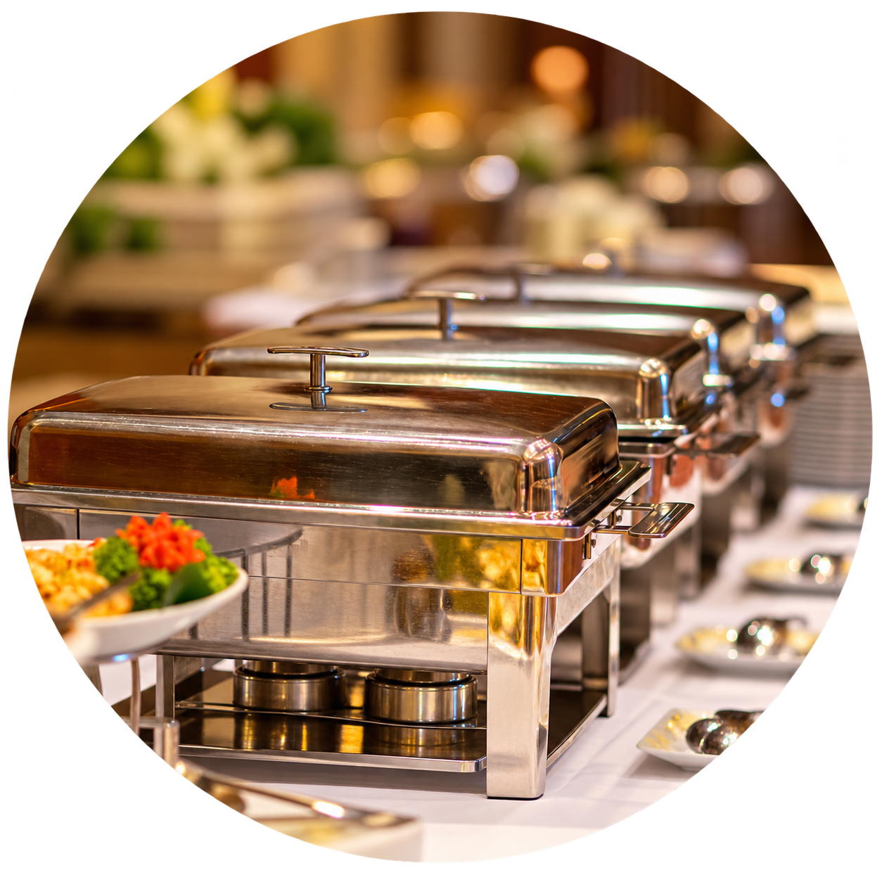 Polished chafing dishes arranged on a warmly lit catering buffet